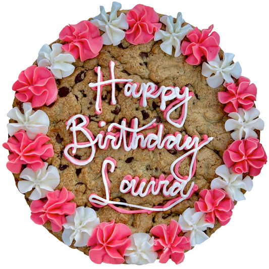 Pink and white cookie cake with custom message and piped frosting border.