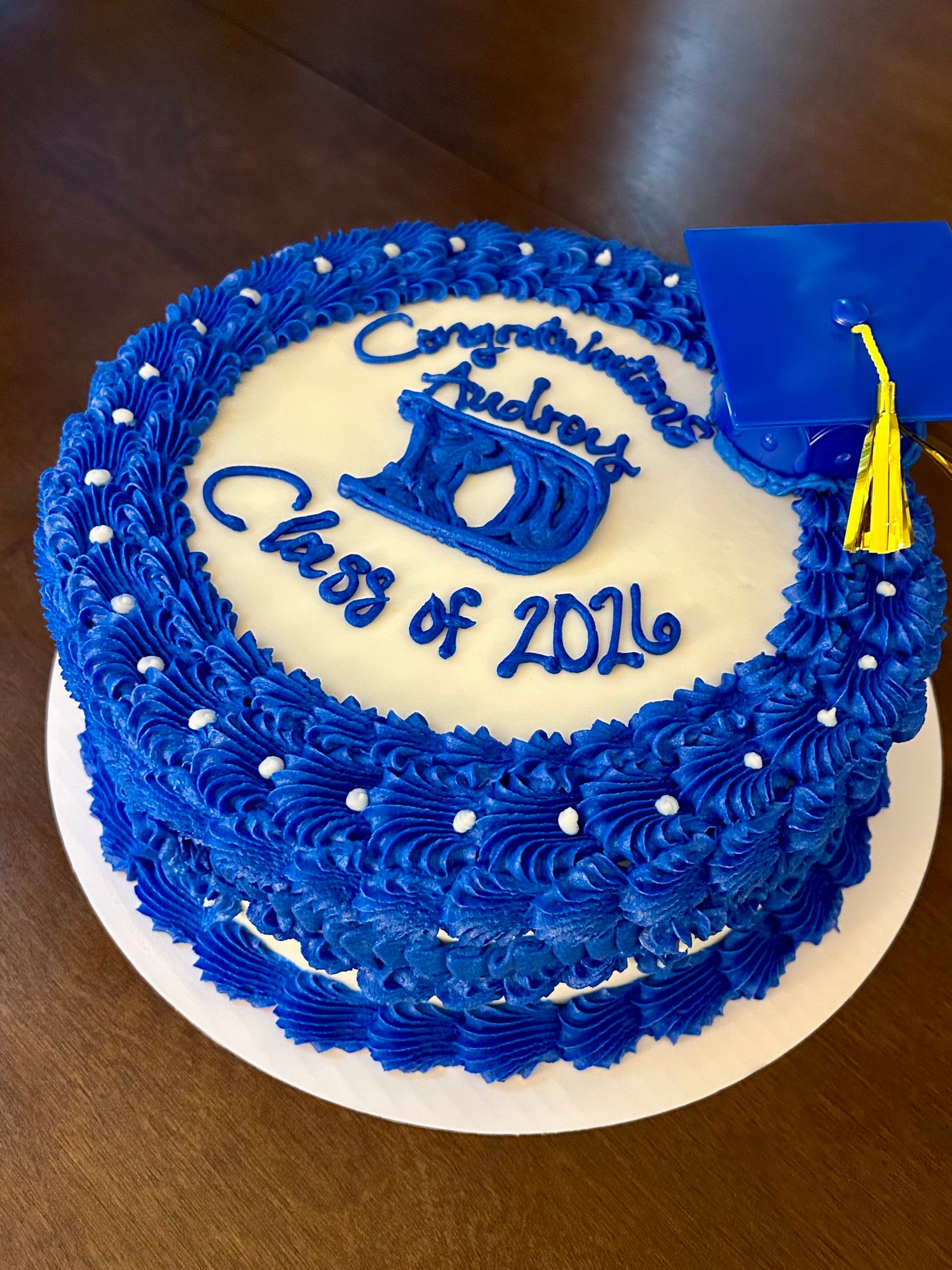 Graduation-themed cake with blue icing and 'Class of 2026' text