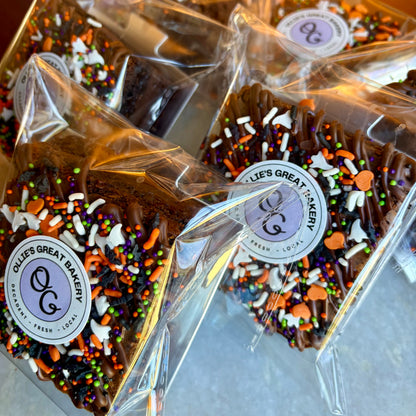 Individually wrapped halloween sprinkle brownies in plastic wrapping with Ollie's Great Bakery logos stickered on top.
