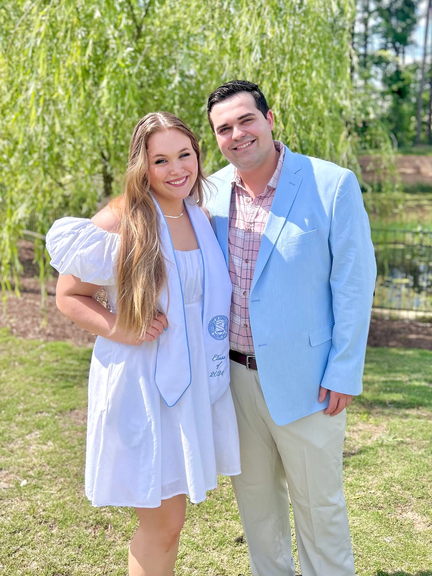 Portrait of husband and wife in UNC graduation outfit and matching suit.