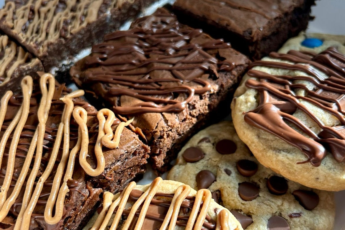 Close-up of assorted brownies and assorted cookies with chocolate and peanut butter drizzle.