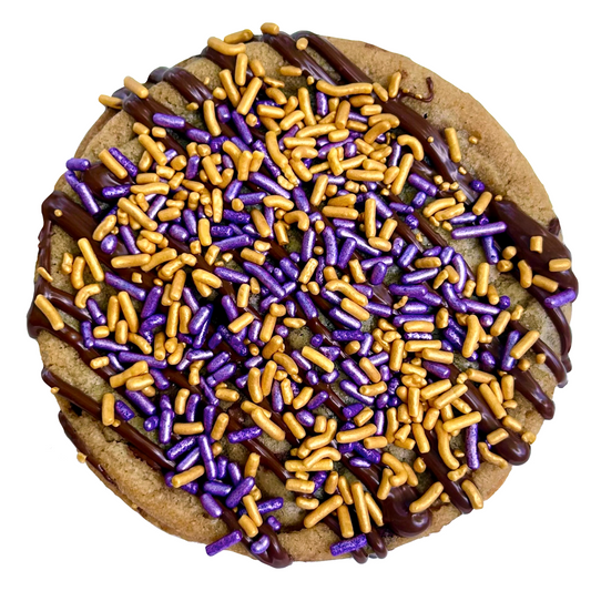 Purple and gold sprinkle cookie with chocolate drizzle and purple and gold sprinkles.