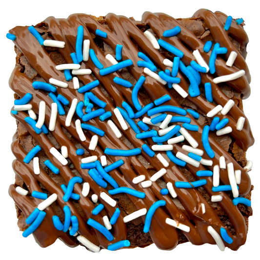 Royal blue sprinkle brownie with chocolate drizzle and white and royal blue sprinkles.