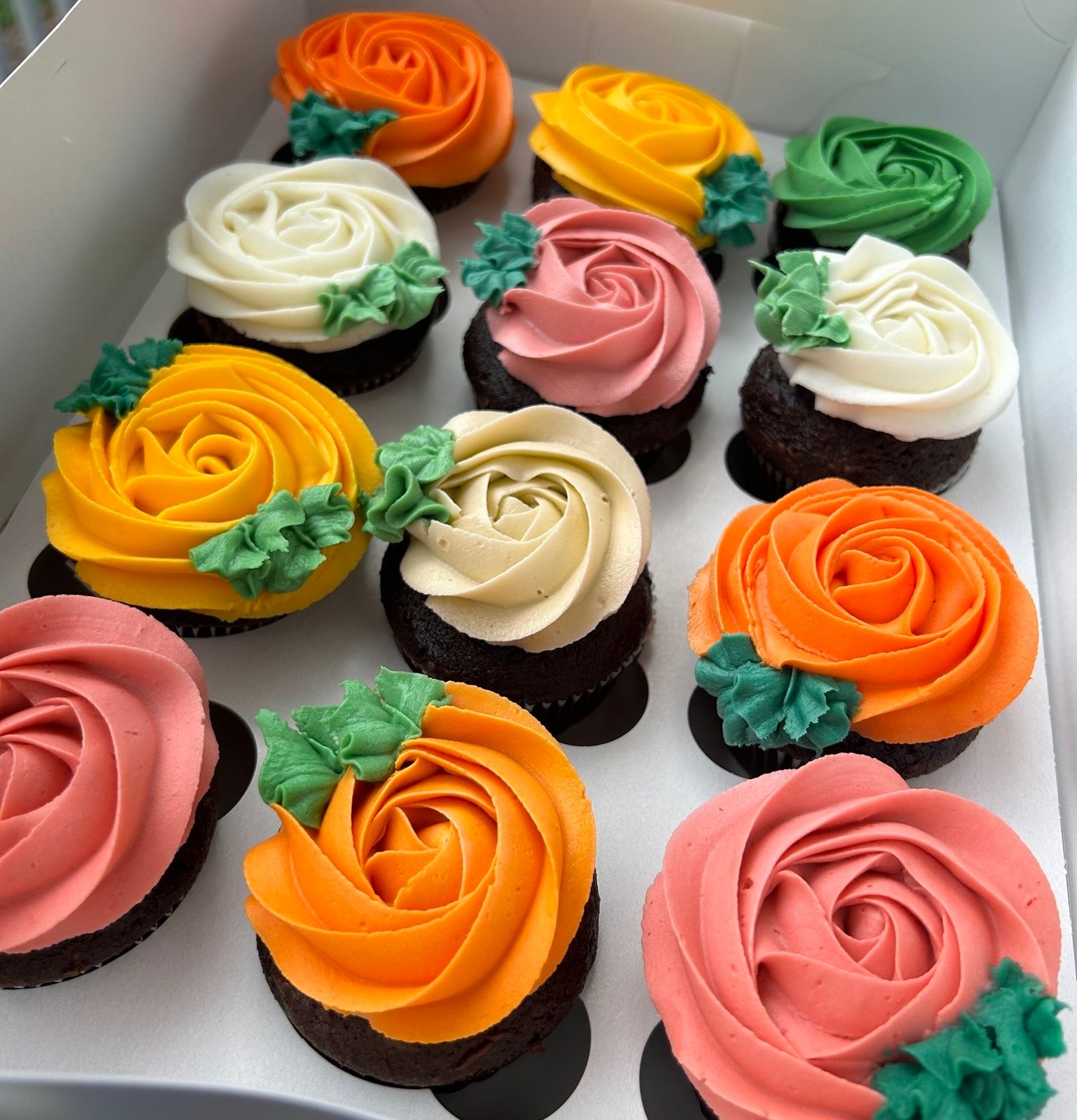 Decorative rose cupcakes with fall floral designs in various autumn colors.